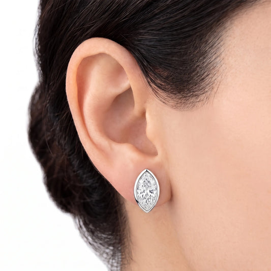 Marquise cut bezel diamond stud earring in white gold worn on ear
