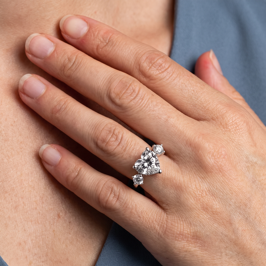 18 KT White Gold Heart Cut Diamond Three Stone Engagement Ring with Hidden Halo - worn close-up