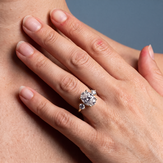 18 KT Yellow Gold Oval Cut Diamond Three Stone Engagement Ring with Hidden Halo - worn close-up