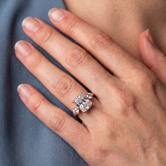 14 KT Rose Gold Radiant Cut Diamond Three Stone Engagement Ring with Hidden Halo - worn close-up