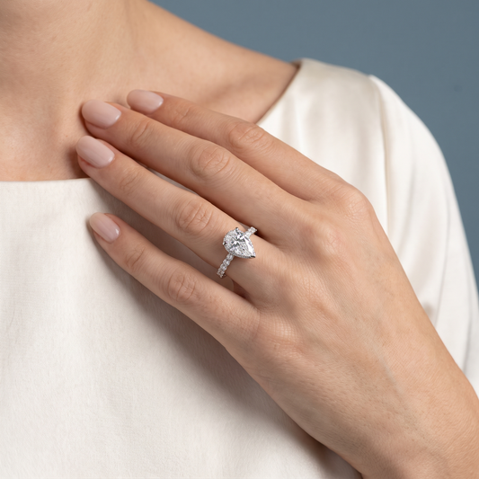 Platinum Pear Cut Diamond Solitaire Ring with Hidden Halo and Pave Band - worn close-up