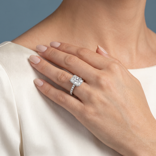 18 KT White Gold Radiant Cut Diamond Solitaire Ring with Hidden Halo and French Pave Band - worn close-up