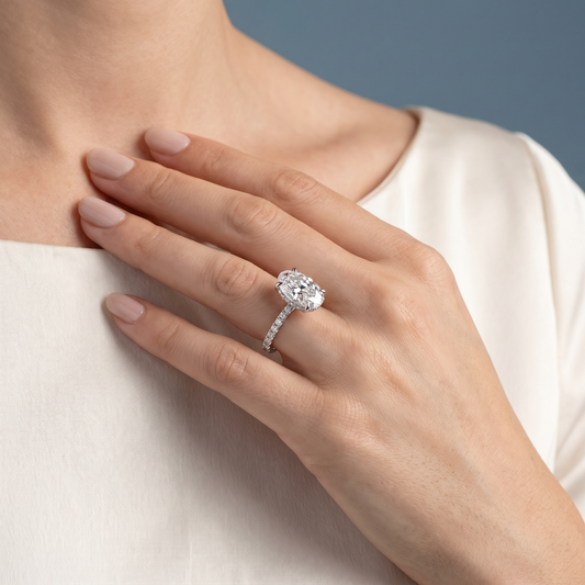 Platinum Oval Cut Diamond Solitaire Ring with Hidden Halo and French Pave Band - worn close-up