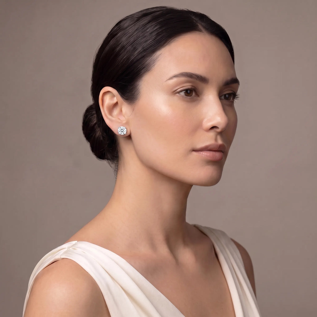 Model wearing round four-prong diamond stud earrings in silver