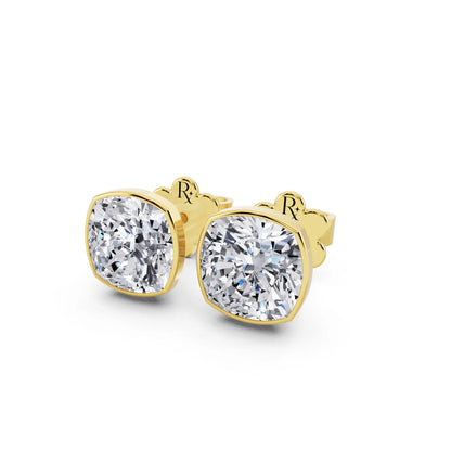 Cushion cut martini-bezel diamond stud earrings in yellow gold, close-up