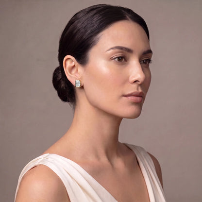 Model wearing radiant cut bezel diamond stud earrings in yellow gold