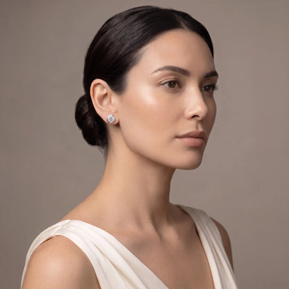 Model wearing round bezel diamond stud earrings in platinum