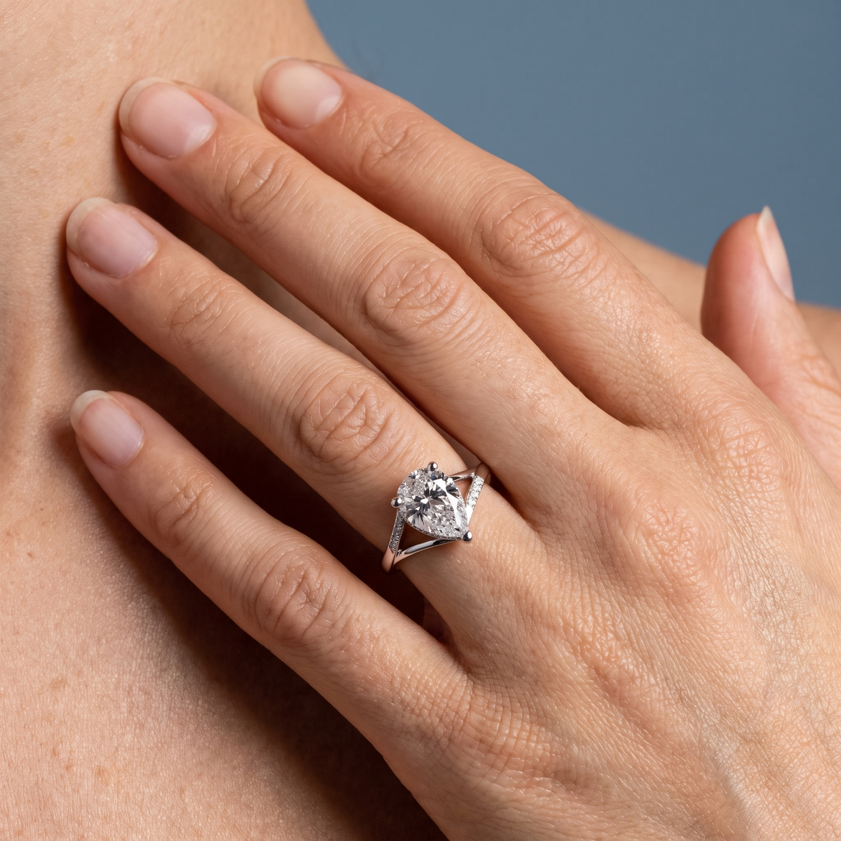 18 KT White Gold Pear Cut Diamond Split Shank Engagement Ring with Hidden Halo - worn close-up