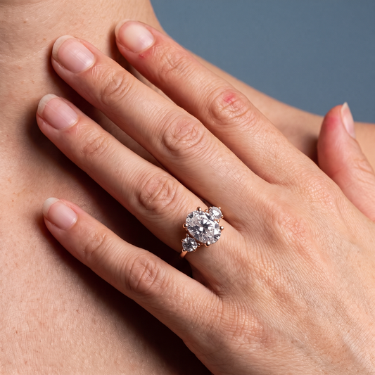 14 KT Rose Gold Oval Cut Diamond Three Stone Engagement Ring with Hidden Halo - worn close-up