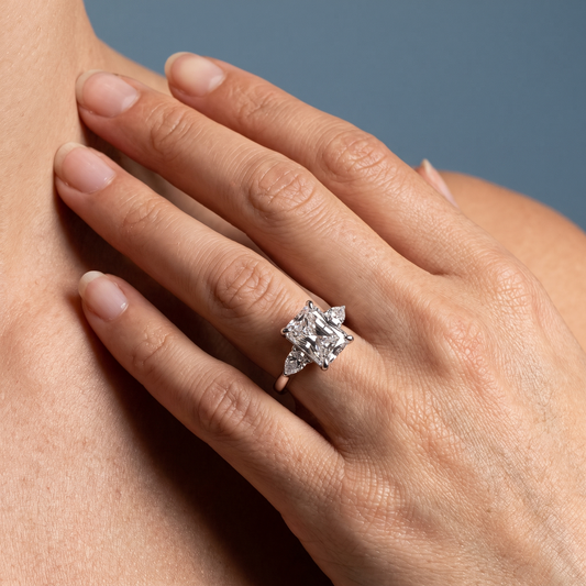 14 KT White Gold Radiant Cut Diamond Cluster Engagement Ring with Pear Accents - worn close-up