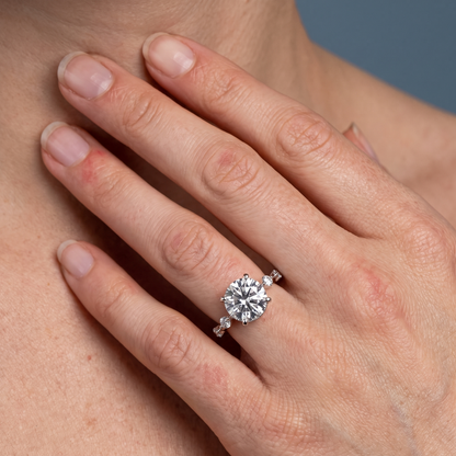 18 KT White Gold Round Cut Diamond Solitaire Ring with Floating Diamond Accents - worn close-up