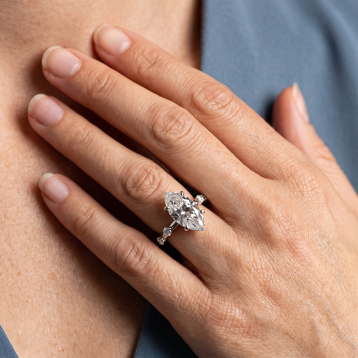 14 KT White Gold Marquise Cut Diamond Solitaire Ring with Floating Diamond Accents - worn close-up