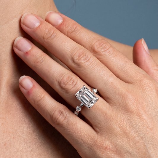 Platinum Emerald Cut Diamond Solitaire Ring with Floating Diamond Accents - worn close-up