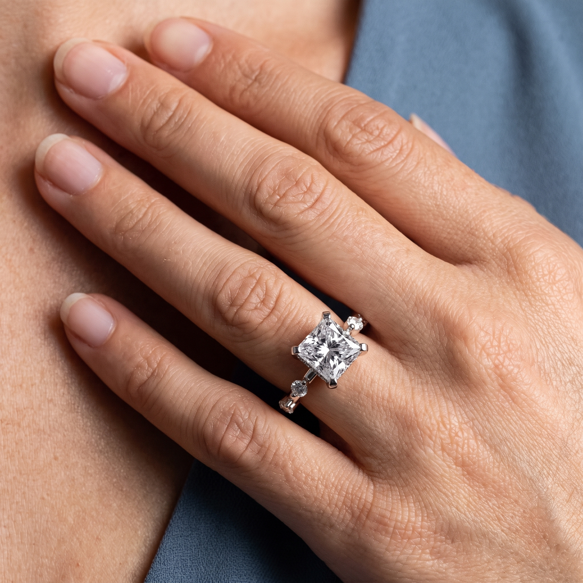 18 KT White Gold Princess Cut Diamond Solitaire Ring with Floating Diamond Accents - worn close-up