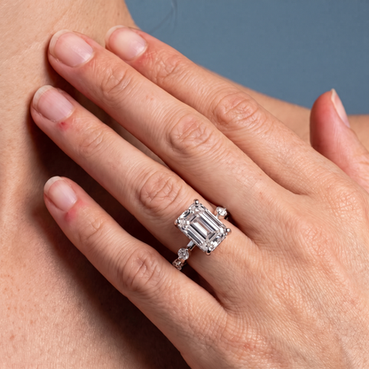 18 KT Yellow Gold Emerald Cut Diamond Solitaire Ring with Floating Diamond Accents - worn close-up