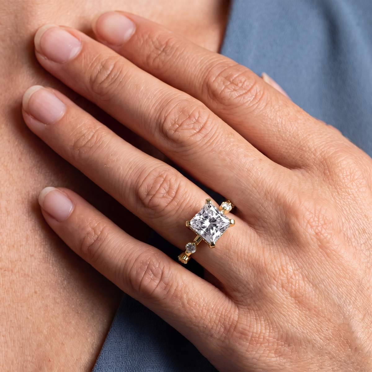 18 KT Yellow Gold Princess Cut Diamond Solitaire Ring with Floating Diamond Accents - worn close-up