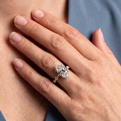 18 KT Yellow Gold Marquise Cut Diamond Solitaire Ring with Floating Diamond Accents - worn close-up