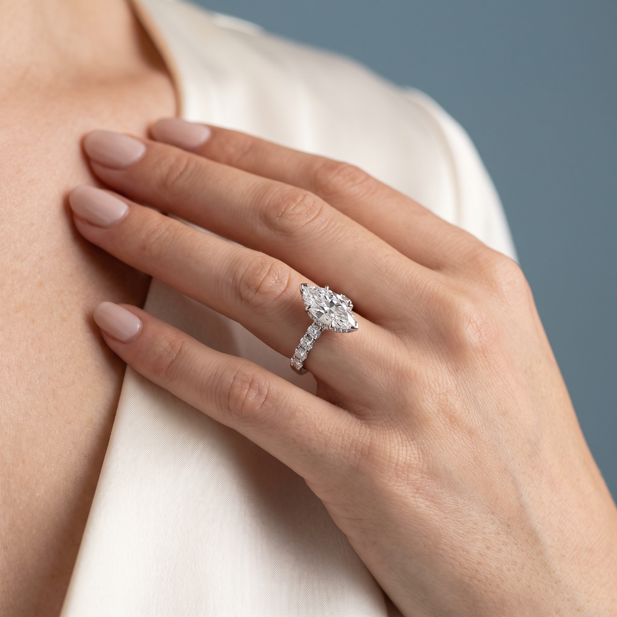 18 KT White Gold Marquise Cut Diamond Solitaire Ring with Hidden Halo and Pave Band - worn close-up