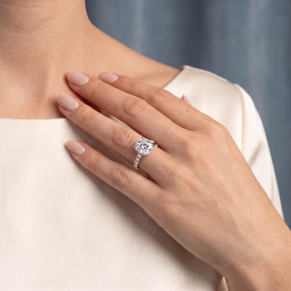 18 KT Rose Gold Cushion Cut Diamond Solitaire Ring with Hidden Halo and Pave Band - worn close-up