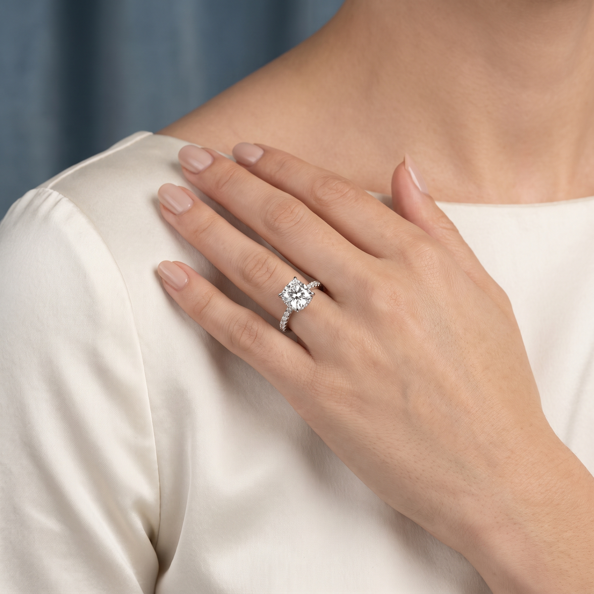 Platinum Cushion Cut Diamond Solitaire Ring with Hidden Halo and French Pave Band - worn close-up