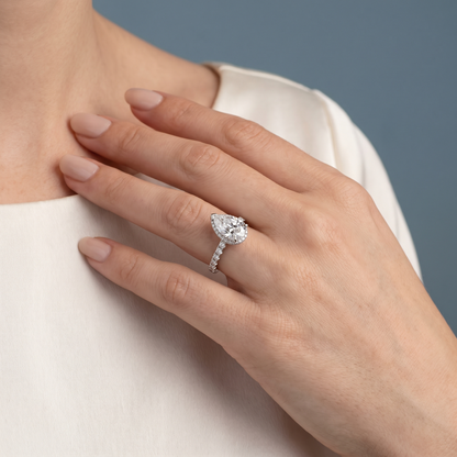 Platinum Pear Cut Diamond Solitaire Ring with Hidden Halo and French Pave Band - worn close-up