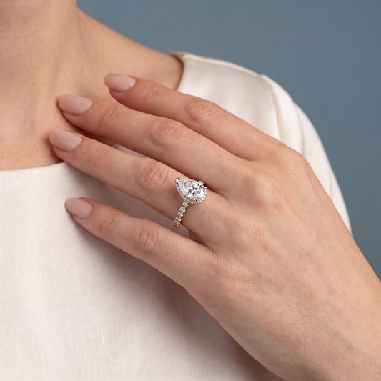 18 KT Rose Gold Pear Cut Diamond Solitaire Ring with Hidden Halo and French Pave Band - worn close-up