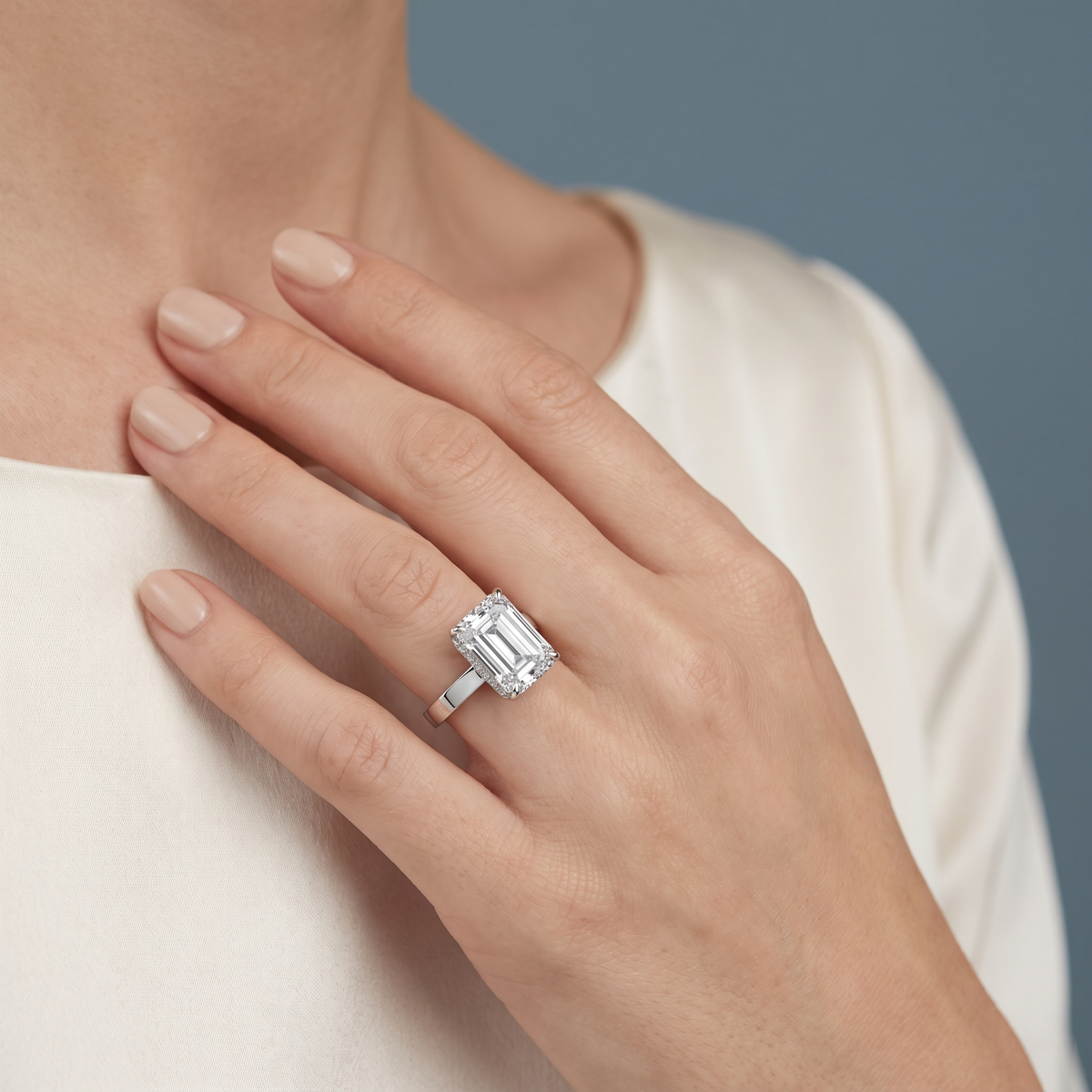 18 KT White Gold Emerald Cut Diamond Solitaire Ring with Hidden Accent - worn close-up