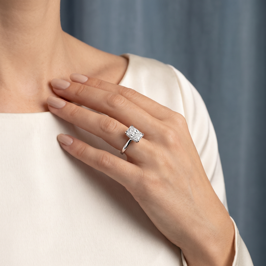 18 KT White Gold Radiant Cut Diamond Solitaire Ring with Hidden Accent - worn close-up