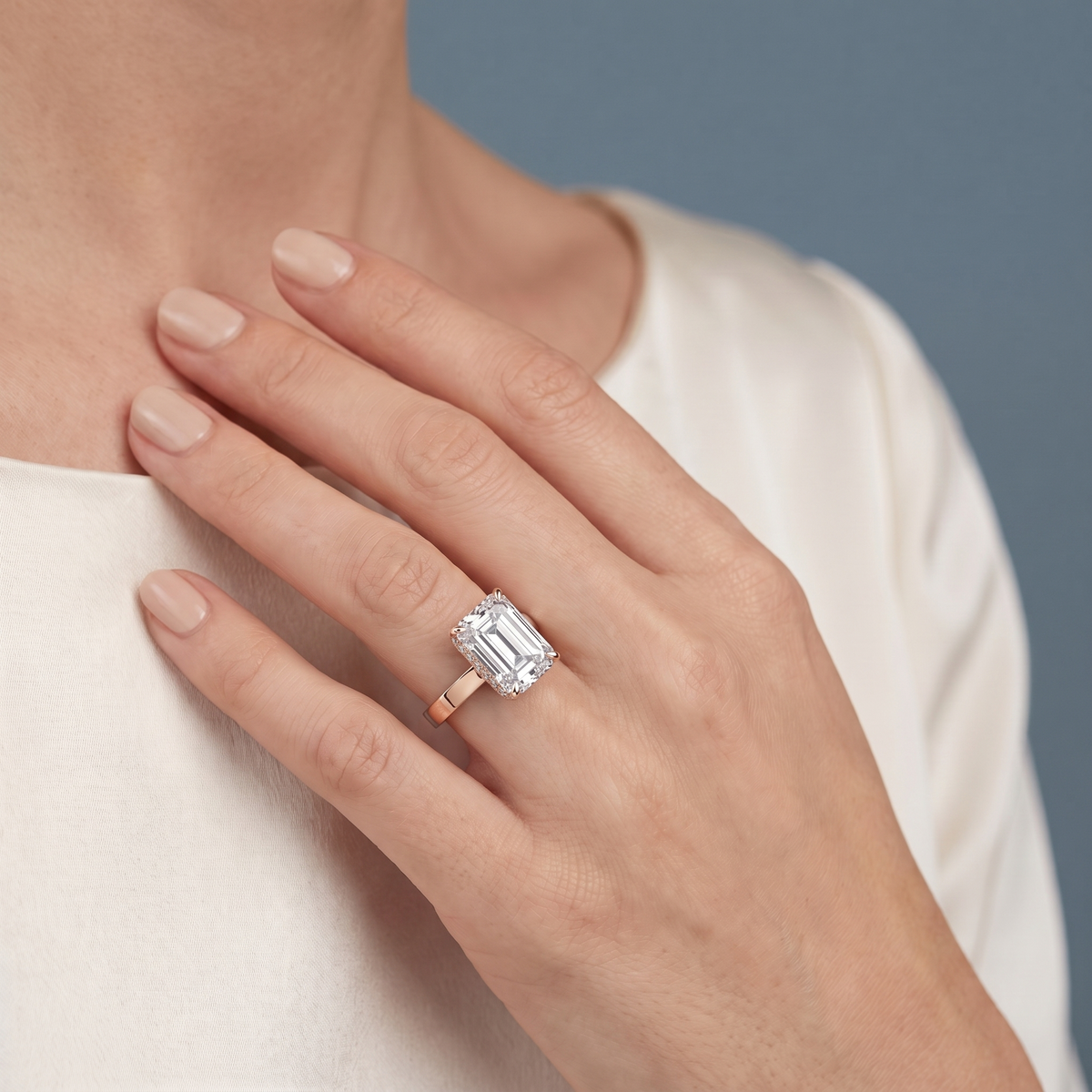 14 KT Rose Gold Emerald Cut Diamond Solitaire Ring with Hidden Halo - worn close-up