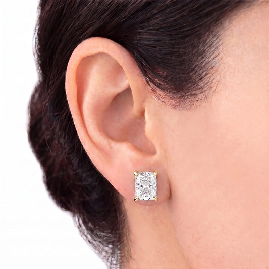 Radiant cut tiger-prong diamond stud earring in yellow gold worn on ear