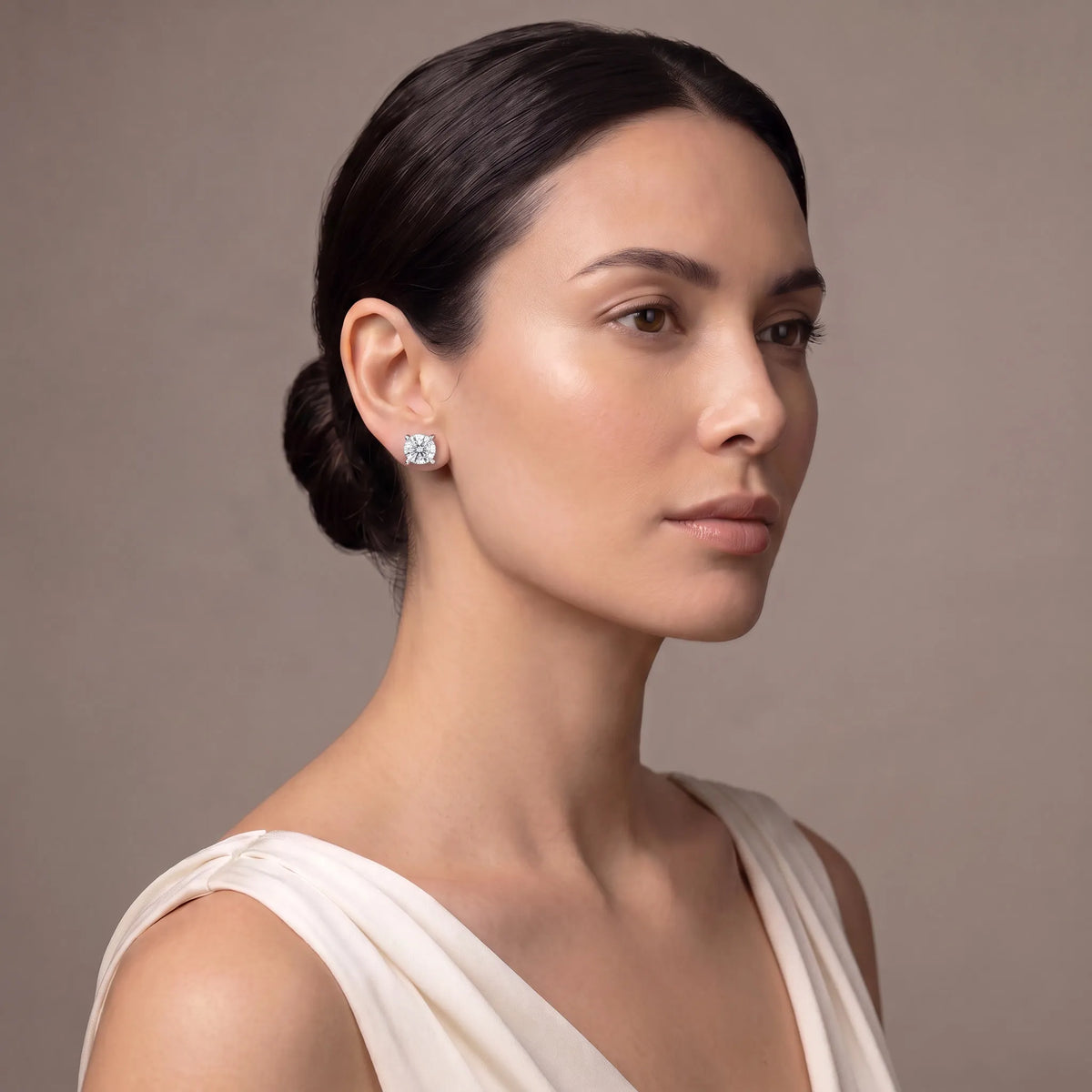 Model wearing round tiger-prong diamond stud earrings in silver
